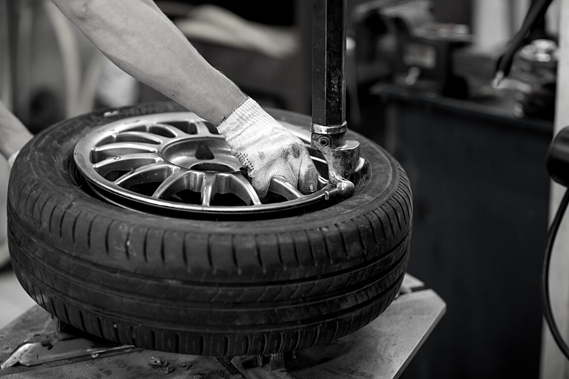 Mechanic Changing Car Tire Fitting. Wheel Tyre Repairing.